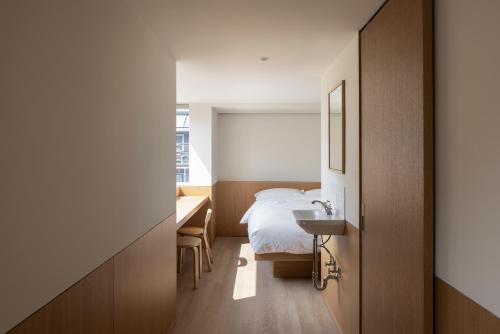 a bedroom with a bed and a desk and a sink at arrdep in Seoul