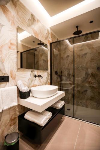 a bathroom with a sink and a shower at LUNA Gallery Suites in Naples