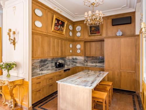 une cuisine avec des placards en bois et un grand îlot dans l'établissement Merveil - Signature Suite - Marais - Braque, à Paris