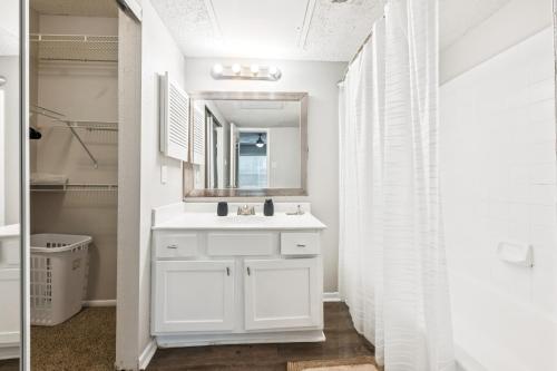 ein weißes Badezimmer mit Waschbecken und Spiegel in der Unterkunft The Davis 916 I Comfy 2 Bed 2 Bath in Huntsville