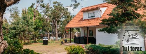a small house with an orange roof at Tu i teraz- Domek wypoczynkowy in Kamienica Królewska