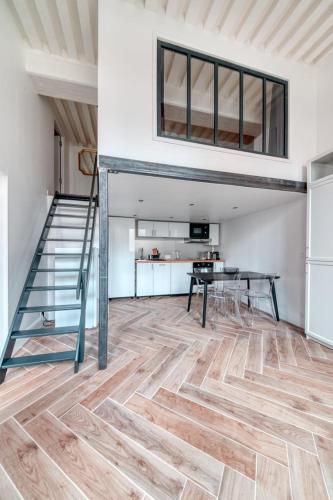 a room with a staircase and a table and a kitchen at Le Pouteau charme authentique 2 chambres in Lyon