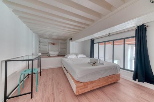 a bedroom with a bed and a glass table at Le Pouteau charme authentique 2 chambres in Lyon