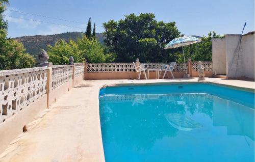a swimming pool with a table and an umbrella at Beautiful Home In Xàtiva With Private Swimming Pool, Can Be Inside Or Outside in Xàtiva