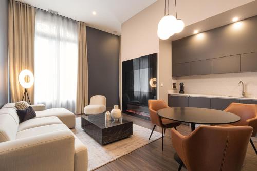 a living room with a couch and a table at Legend Majestic - Parking Privé GRATUIT- Climatisation - Gare - Centre Ville - FIBRE in Mâcon