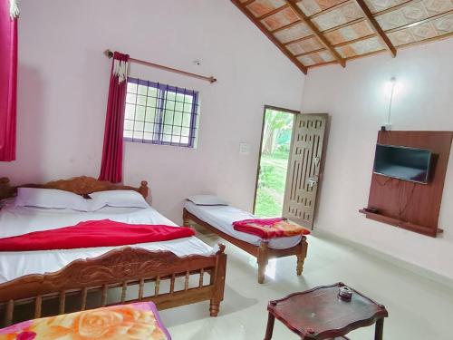 a bedroom with two beds and a tv in it at Rainbow Villa in Chikmagalūr
