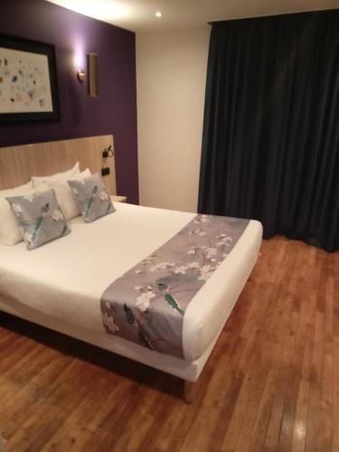 Una cama o camas en una habitación de Hotel Modern Est