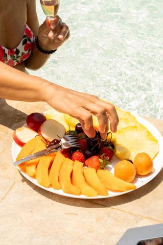a plate of fruit on a table next to a pool at B&B Casale Ansamagi Relax & Pool in Genzano di Roma