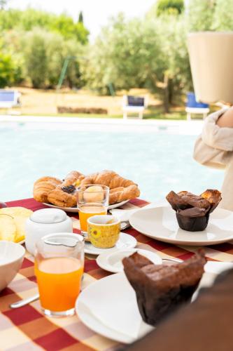 a table with bread and orange juice and food on it at B&B Casale Ansamagi Relax & Pool in Genzano di Roma