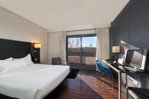 Habitación de hotel con cama grande y TV en Eurostars Monte Real, en Madrid