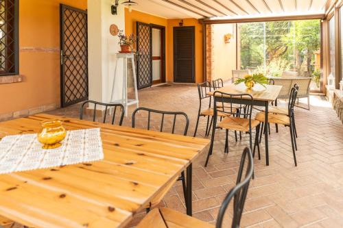 an outdoor patio with wooden tables and chairs at B&B Casale Ansamagi Relax & Pool in Genzano di Roma