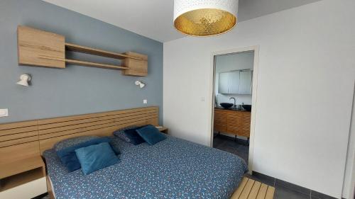 a bedroom with a bed with blue pillows on it at Bienvenue chez PO et Marie in Montferrier-sur-Lez