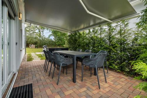 a patio with a table and chairs under a canopy at Seeglück 1 am Tollensesee in Groß Nemerow