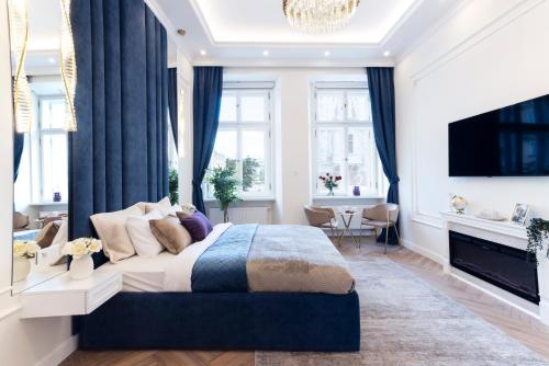 a bedroom with a large bed with blue curtains at Main Square Apartments in Krakow