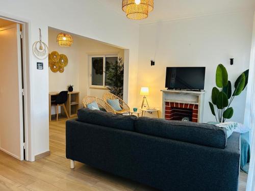 a living room with a couch and a fireplace at Caparica Beach House Holiday Home in Costa da Caparica