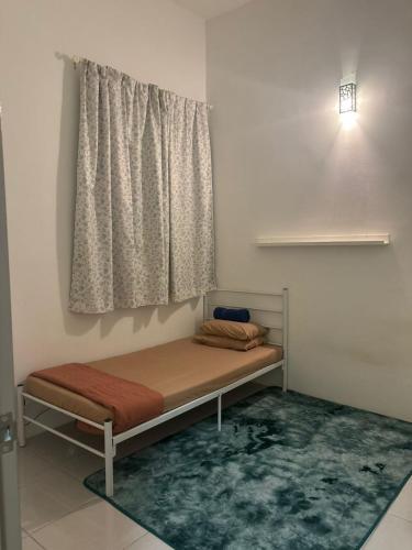 a bed in a room with a window and a rug at Nameera Stay Bandar Universiti Seri Iskandar in Seri Iskandar