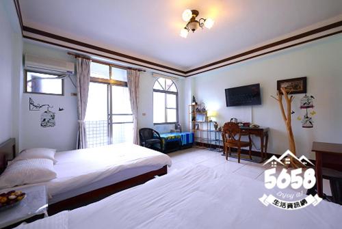 富里郷にあるMatisse B&Bのベッドと机とテレビのある寝室