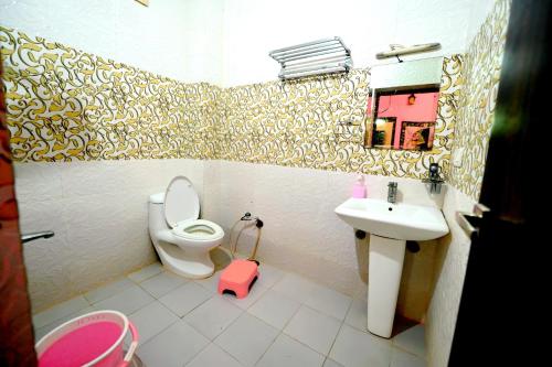 a small bathroom with a toilet and a sink at Chandra Safari Hotel Jaisalmer in Jaisalmer