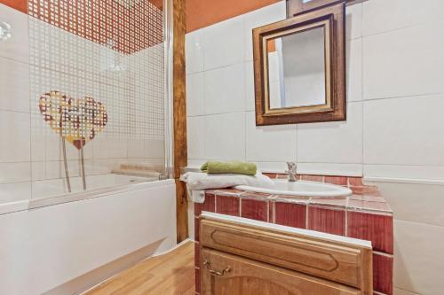 a bathroom with a tub and a sink and a mirror at Gite Bastide in Bargème