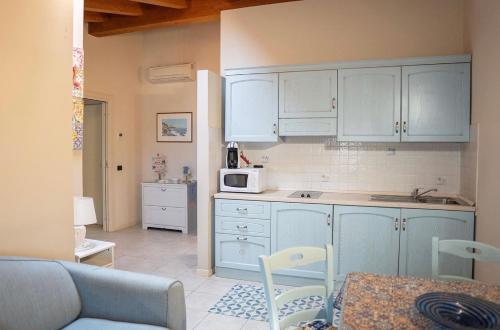a kitchen with blue cabinets and a microwave at Residence Cà di Capri in Bussolengo