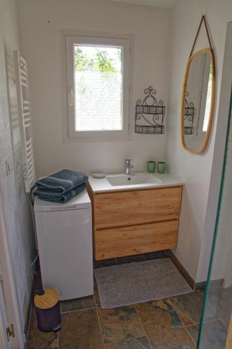 une salle de bain avec un lavabo et un miroir dans l'établissement L'écrin de la Garrigue, à Saint-Siffret