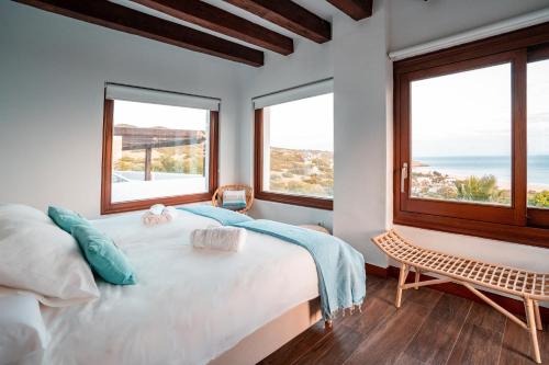 a bedroom with a large bed and two windows at The Cube in Zahara de los Atunes