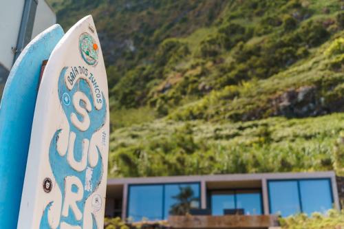 two surfboards standing in front of a house with a mountain at GuestReady - Relax & Ride the Waves in São Vicente