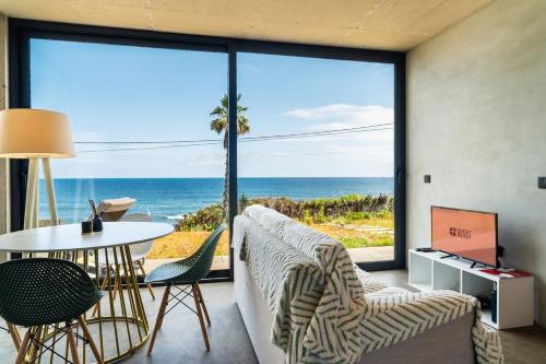 a living room with a view of the ocean at GuestReady - Relax & Ride the Waves in São Vicente