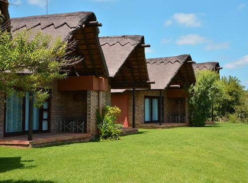 a house with a green lawn in front of it at Kloofzicht Lodge & Spa in Muldersdrift