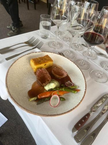 a plate of food on a table with wine glasses at Örserumsbrunn Gestgifveri & Konferens in Gränna