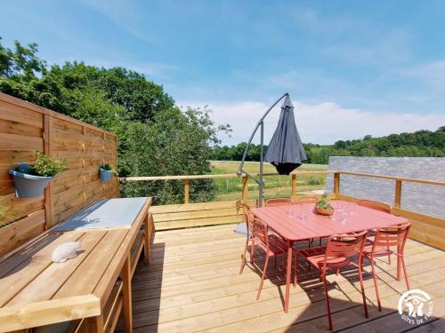 a wooden deck with a table and chairs on the water at Le Logis des Vallées, 6/7 pers avec piscine et sauna in Ambrieres Les Vallees