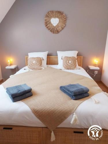 a bedroom with a large bed with two towels on it at Le Logis des Vallées, 6/7 pers avec piscine et sauna in Ambrieres Les Vallees