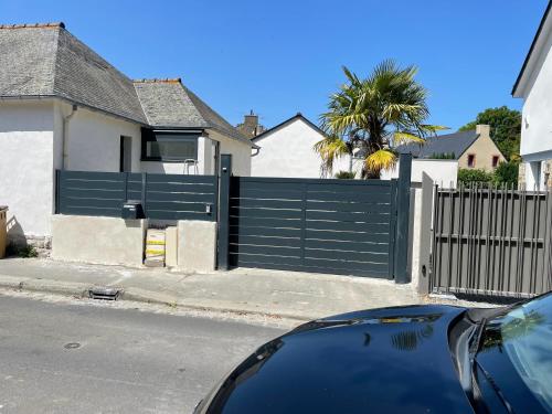 Un coche azul aparcado delante de una valla en Dinard centre, en Dinard
