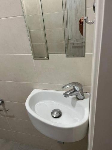 a white sink in a bathroom with a mirror at The Central Collection Apartments in Chişinău
