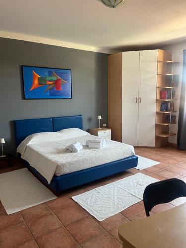 a bedroom with a bed with a painting on the wall at Casa Mimì in Simaxis
