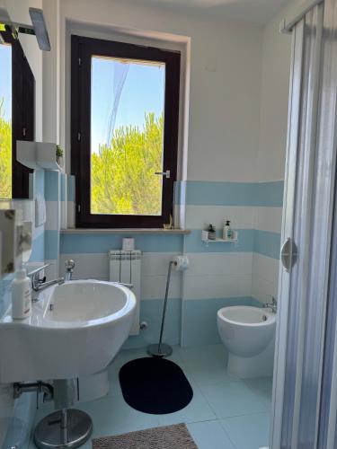 a bathroom with a sink and a toilet and a window at Casa Numana Adamo ed Eva resort in Numana
