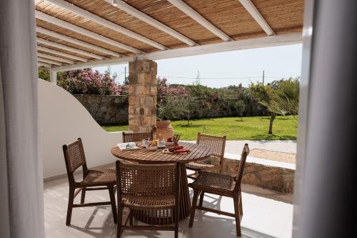 a wooden table and chairs on a patio at Country Villas in Stelida