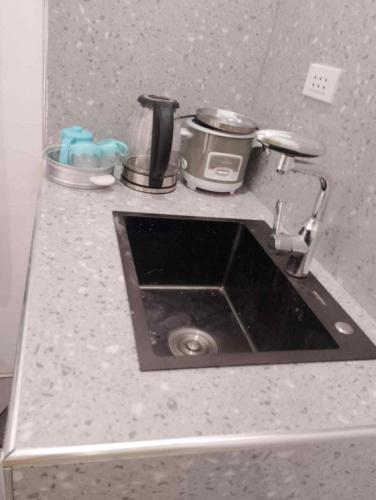 a kitchen counter with a sink and a appliance at NAJJ Inn in Siquijor