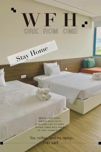 a room with two beds and a sign that says stay home at Hoàng Khang Hotel- Khách Sạn Buôn Ma Thuột in Buôn Kô Sir