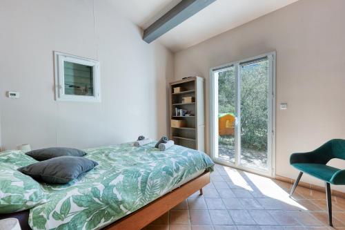 une chambre avec un lit, une chaise et une fenêtre dans l'établissement Villa Provençale avec Piscine dans la nature, à Solliès-Toucas