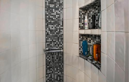 a bathroom with a shower with black and white tiles at 3 Bedroom Awesome Home In Kalmar in Böda