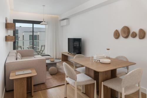 a living room with a couch and a table and chairs at Acqua Residence VI by An Island Apart in Funchal