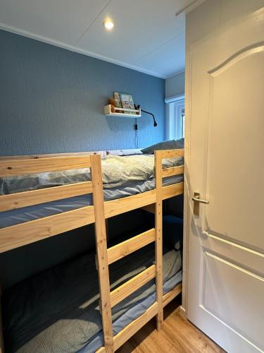 a room with two bunk beds and a door at Chalet Aan de rand - Veluwe - met sauna in Putten