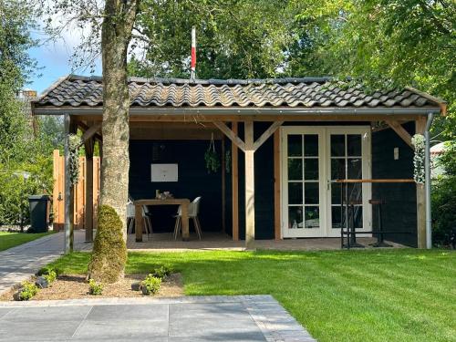 a gazebo with a table in a yard at Chalet Aan de rand - Veluwe in Putten