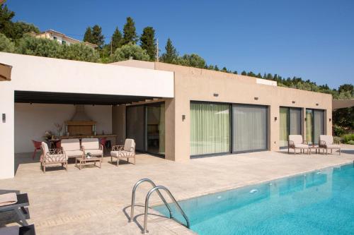 a house with a swimming pool and a patio at Bitter Almond Trees in Nikiana