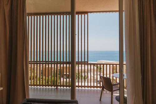 a room with a balcony with a view of the ocean at MIKU Green Coast in Palasë