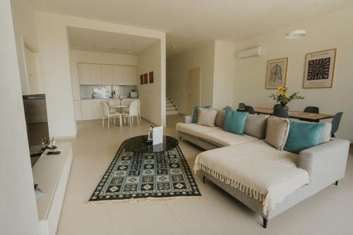a living room with two couches and a table at MIKU Green Coast in Palasë