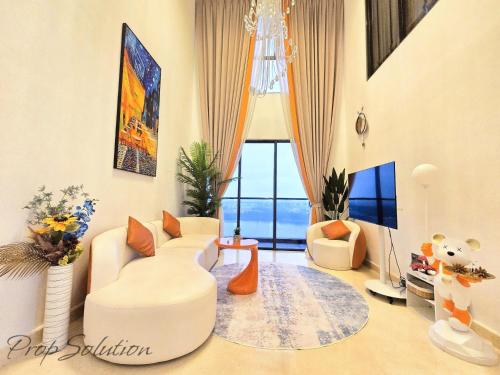 un salon avec des meubles blancs et une grande fenêtre dans l'établissement Loft Suite Seaview 2BR JB CIQ 7Pax, à Johor Bahru