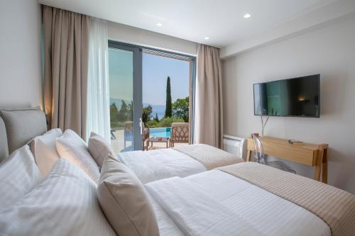 a hotel room with two beds and a large window at Bitter Almond Trees in Nikiana