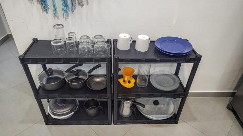 a shelf with pots and pans and utensils on it at Apartamento Sol da Manhã in Morro de São Paulo